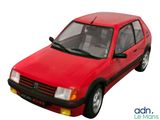 une petite voiture rouge posée sur une surface blanche