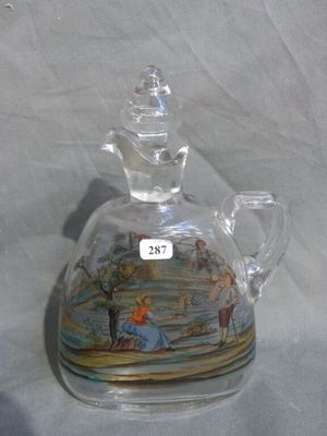 a glass bottle with a picture on it on a table