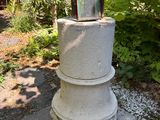 a small lantern sitting on top of a stone pillar