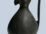 a small black vase with a bird on it