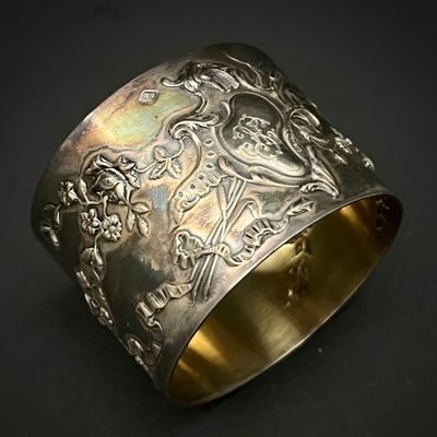 gros plan d'un bracelet en argent sur une surface noire
