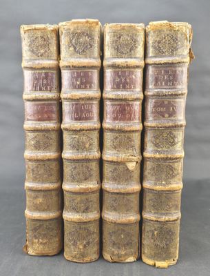 four old books stacked on top of each other on a table