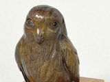 pair of bronze owl figurines on marble base on white background