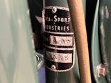 a close up of a green motorcycle with a brown handle