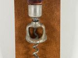 a bottle opener with a wine cork and a hat on it