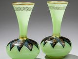 pair of green glass vases with black and gold designs on them