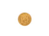 gros plan d'une pièce d'or sur une surface blanche