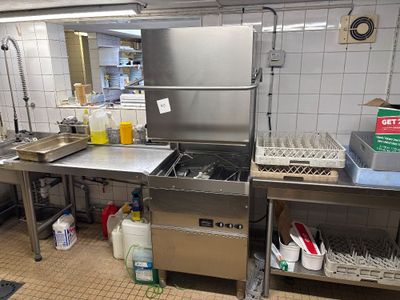 une grande cuisine en inox équipée d'un évier et d'un lave-vaisselle