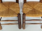 two wooden chairs that are sitting next to each other