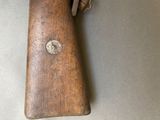 a small wooden gun with a leather case on a table