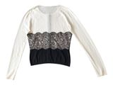 a close up of a white top with black lace on it