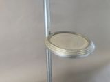 a toilet with a lid on a stand in a bathroom