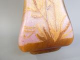 un vase rose et doré posé sur une table blanche