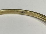 an image of a close up of a gold bracelet on a white surface