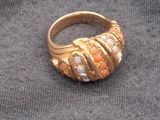 a gold ring that is on a black cloth