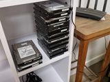 a stack of hard drives and a laptop on a white shelf