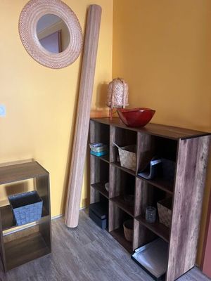 a wooden shelf with a bowl on top of it in the corner of a room
