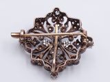 a close up of a brooch with a cross on it