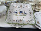 many plates and bowls on the table with a bird on them