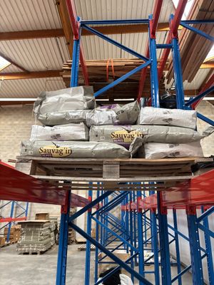 une grande pile de sacs posée sur une palette dans un entrepôt
