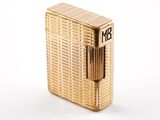 l'image d'un briquet doré posé sur une surface blanche