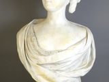 a white marble bust of a woman on a gold stand