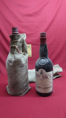 two bottles of wine sitting next to each other on a red surface