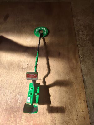 un petit objet vert posé sur une table en bois