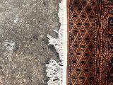 une personne debout à côté d'un tapis posé par terre