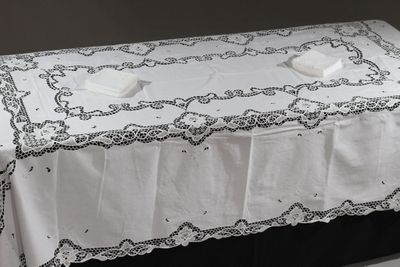 une table recouverte d'une nappe blanche et sur laquelle se trouve une serviette