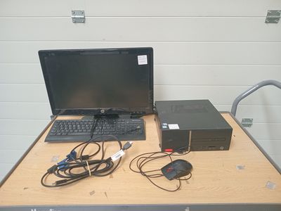 un ordinateur portable posé sur une table, à côté d'une souris et d'un clavier