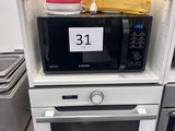 several microwaves are stacked on top of each other in a kitchen
