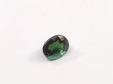 a green tourmaline gems on a white surface