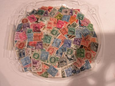 un récipient en plastique rempli de timbres-poste posé sur une table