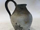 a black and white vase sitting on a white surface
