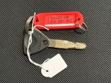 a red keychain with a tag attached to it