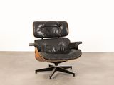 an image of a black leather lounge chair with a wooden base