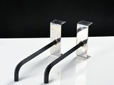 two metal hooks on a white table with a black background