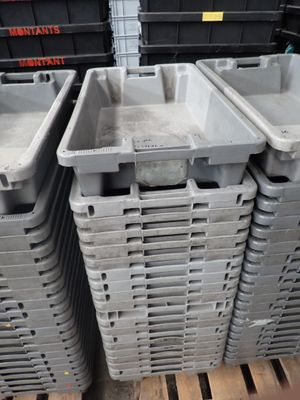 plusieurs conteneurs en plastique empilés les uns sur les autres sur une palette