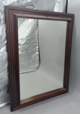 un miroir posé sur le sol à côté d'un mur