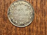 a silver coin sitting on top of a wooden table