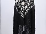 a black shawl with white flowers and fringes on a mannequin