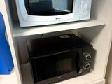 un micro-ondes posé sur un meuble blanc