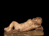 an image of a statue of a person laying down on a black surface