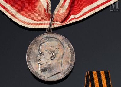 une médaille entourée d'un ruban sur lequel est représenté le visage d'un homme