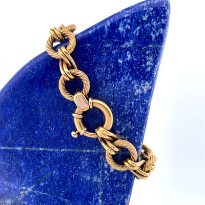 gold plated bracelet with a blue stone on a white background