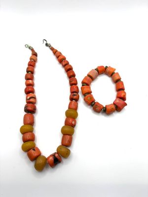 Un collier et un bracelet en perles de bambou teinté orange …