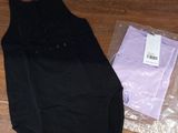 a black dress and a purple shirt on a wooden floor