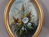une photo d'un tableau de fleurs dans un cadre doré