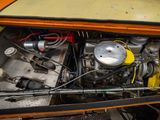a close up of a car engine in the trunk of an orange car